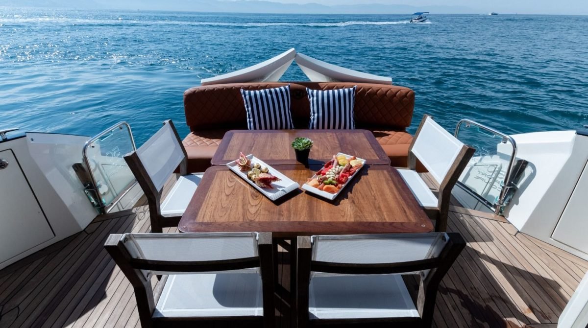 Mesa de teca con botanas en la cubierta de popa del yate Marquis 50 SC, yate privado en Puerto Vallarta para grupos pequeños